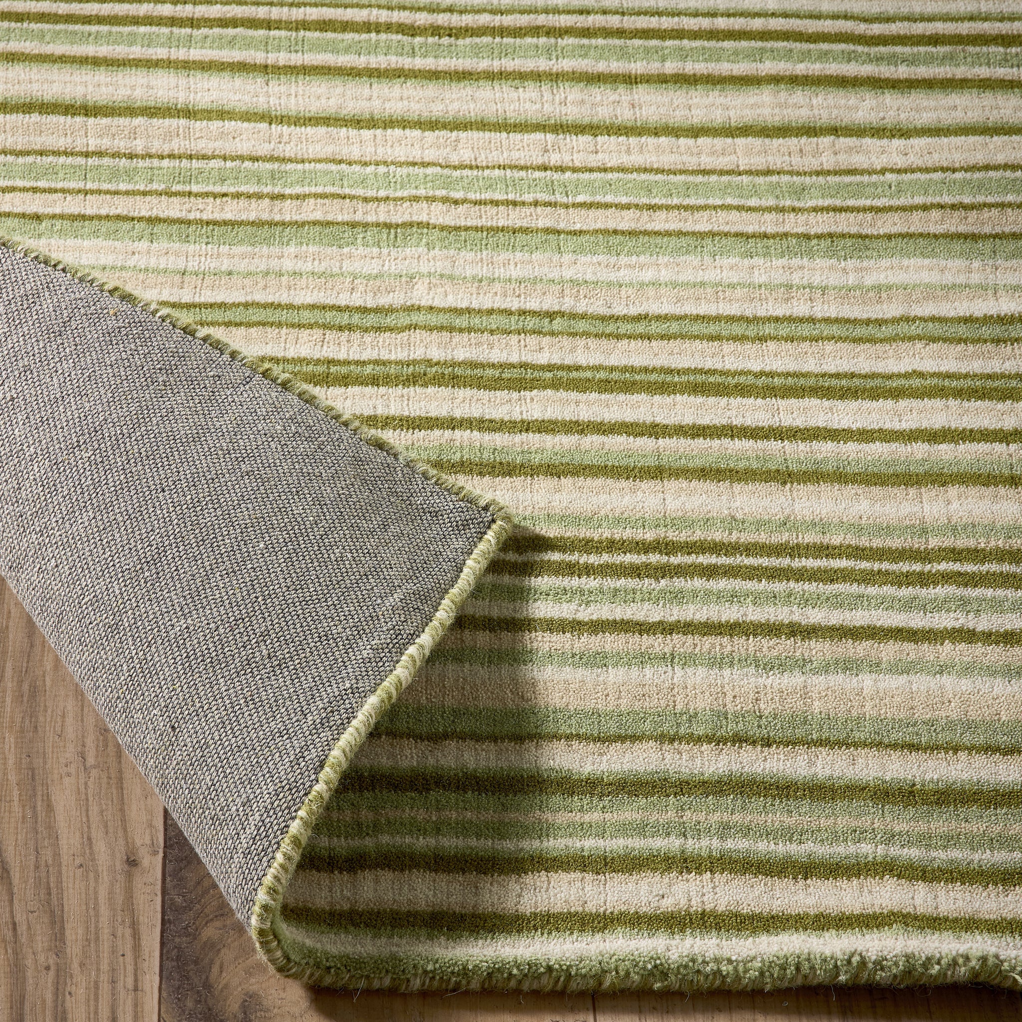 Green Fine Stripe Rug- 100% wool cut pile in green with a striped pattern.