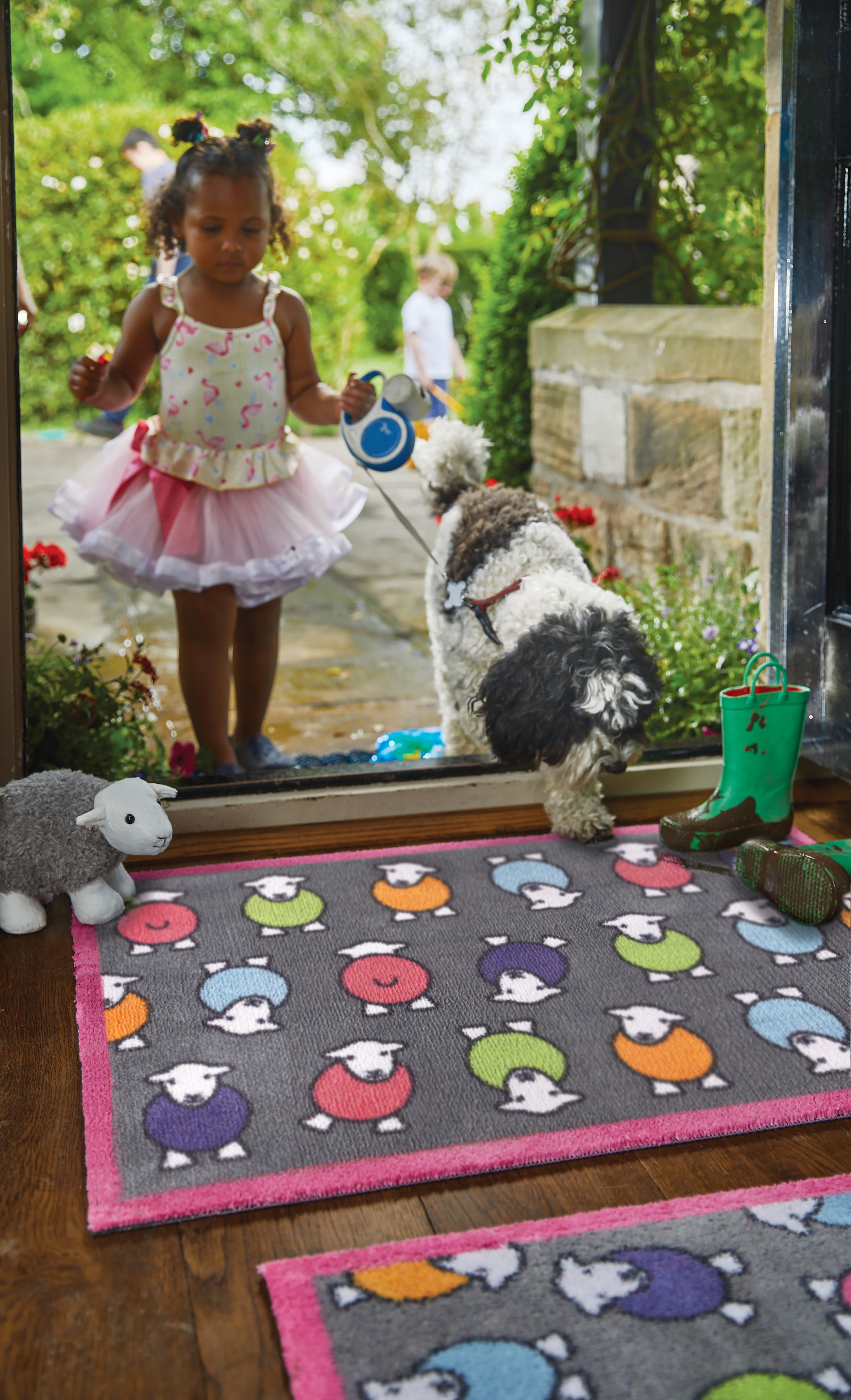 Young child and dog walking across Herdy rug
