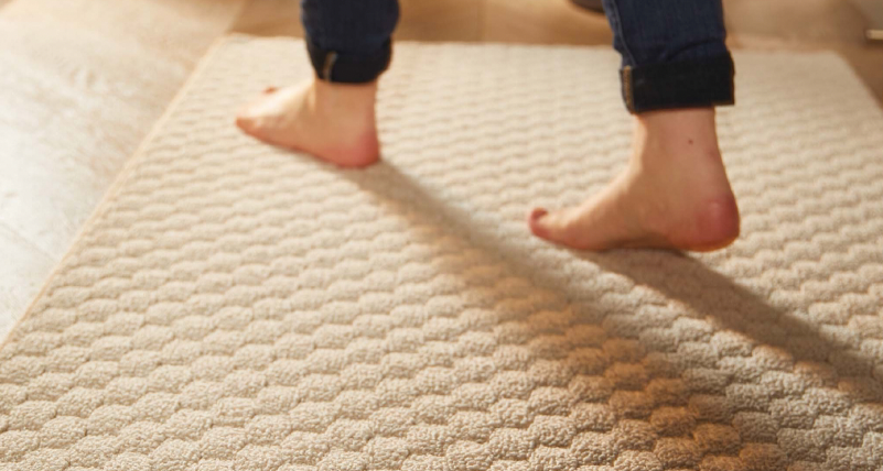 Bare feet walking on a sculptured rug
