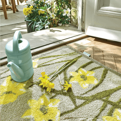 A front door mat with daffodils on