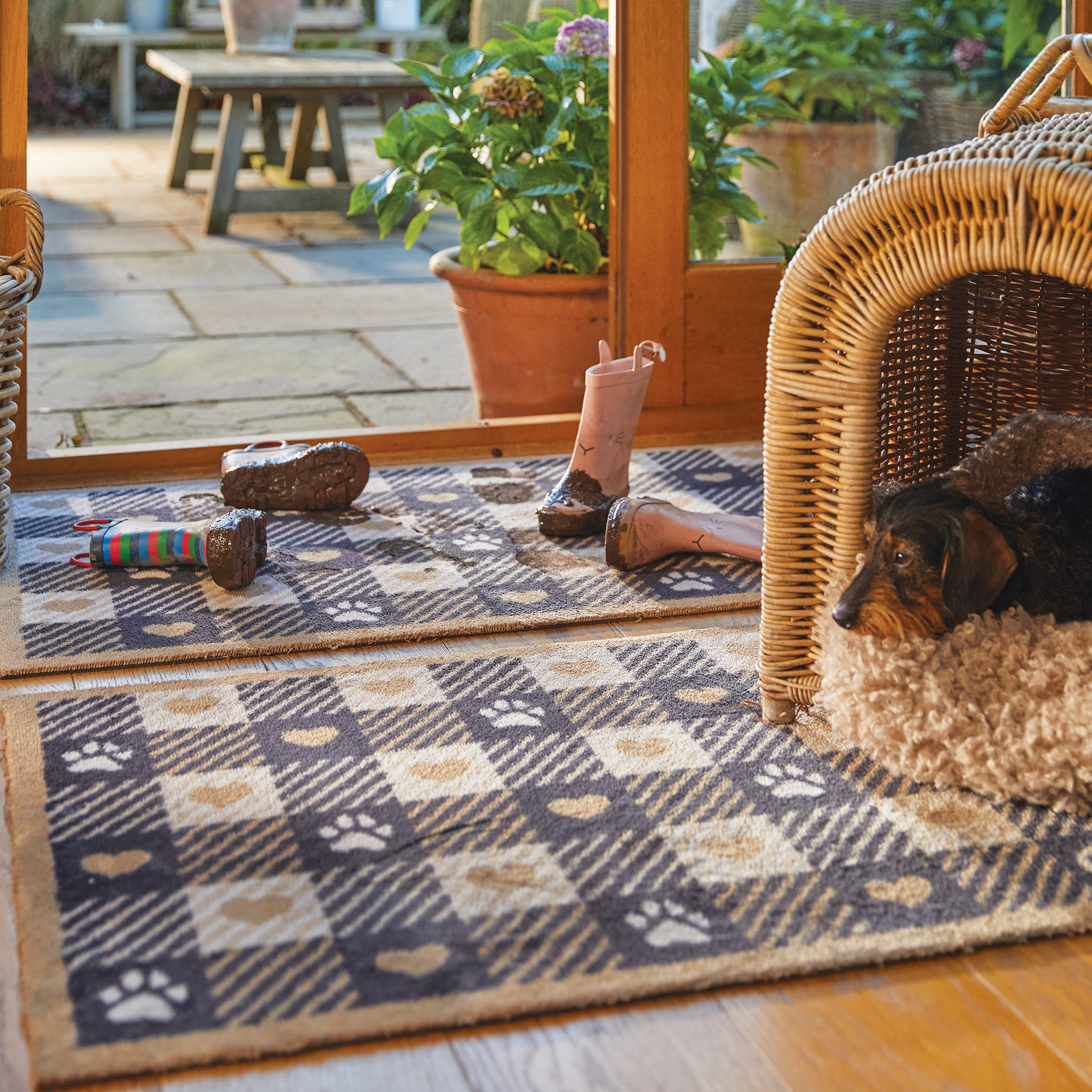 Lifestyle image of a dog lying on a beige Hug Rug Pet Check 1 washable doormat and washable runner