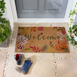 Discover the Autumnal Welcome Coir Doormat- a coir doormat featuring leaves, berries, pumpkins and mushrooms with a graphic font. 