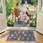 Lifestyle image of a young girl standing in front of a grey marra Herdy washable indoor doormat from Hug Rug