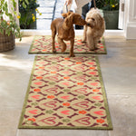 Lifestyle image of two dogs walking on Hug Rug beige hearts and bones washable doormat and washable runner
