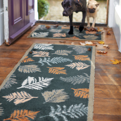 Dog walking through the door onto an autumn patterned mat