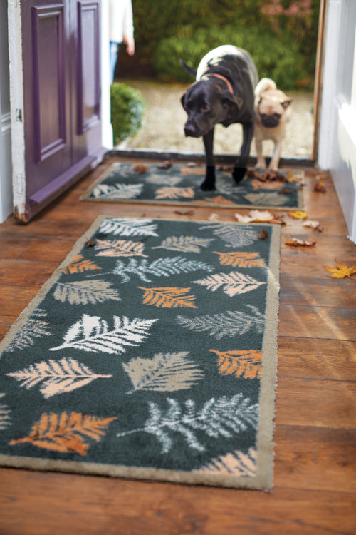 Dog walking through the door onto an autumn patterned mat