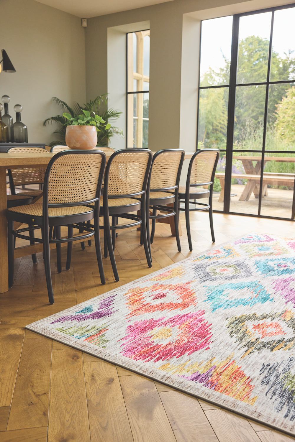 Painted Ikat Washable Rug in a sunny dining room placed on a wooden floor