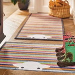 Lifestyle image of muddy wellies on a Peep Stripe Herdy washable doormat and washable hallway runner from Hug Rug