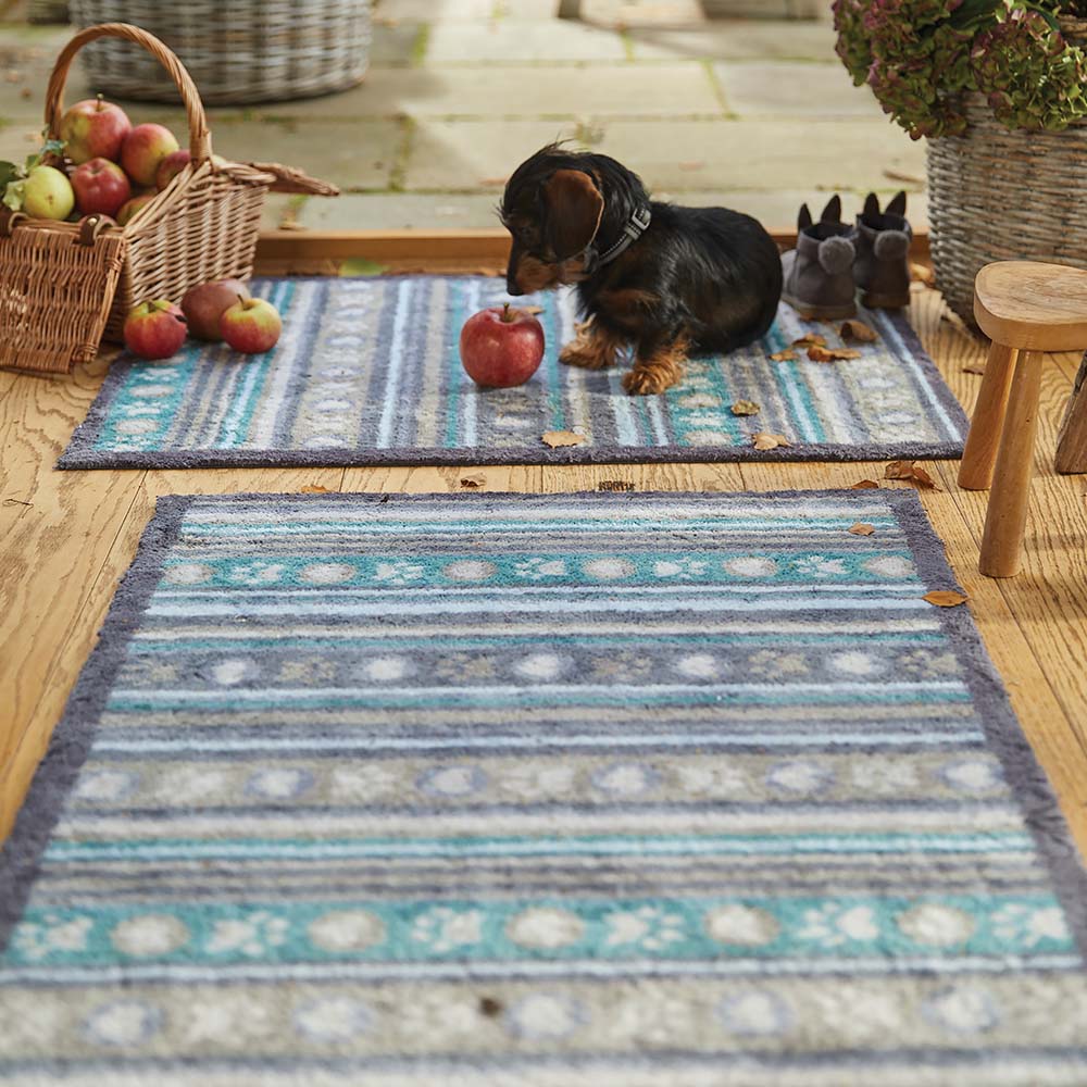 Lifestyle image of a dog sat on the Pet 80 washable doormat and matching runner from Hug Rug