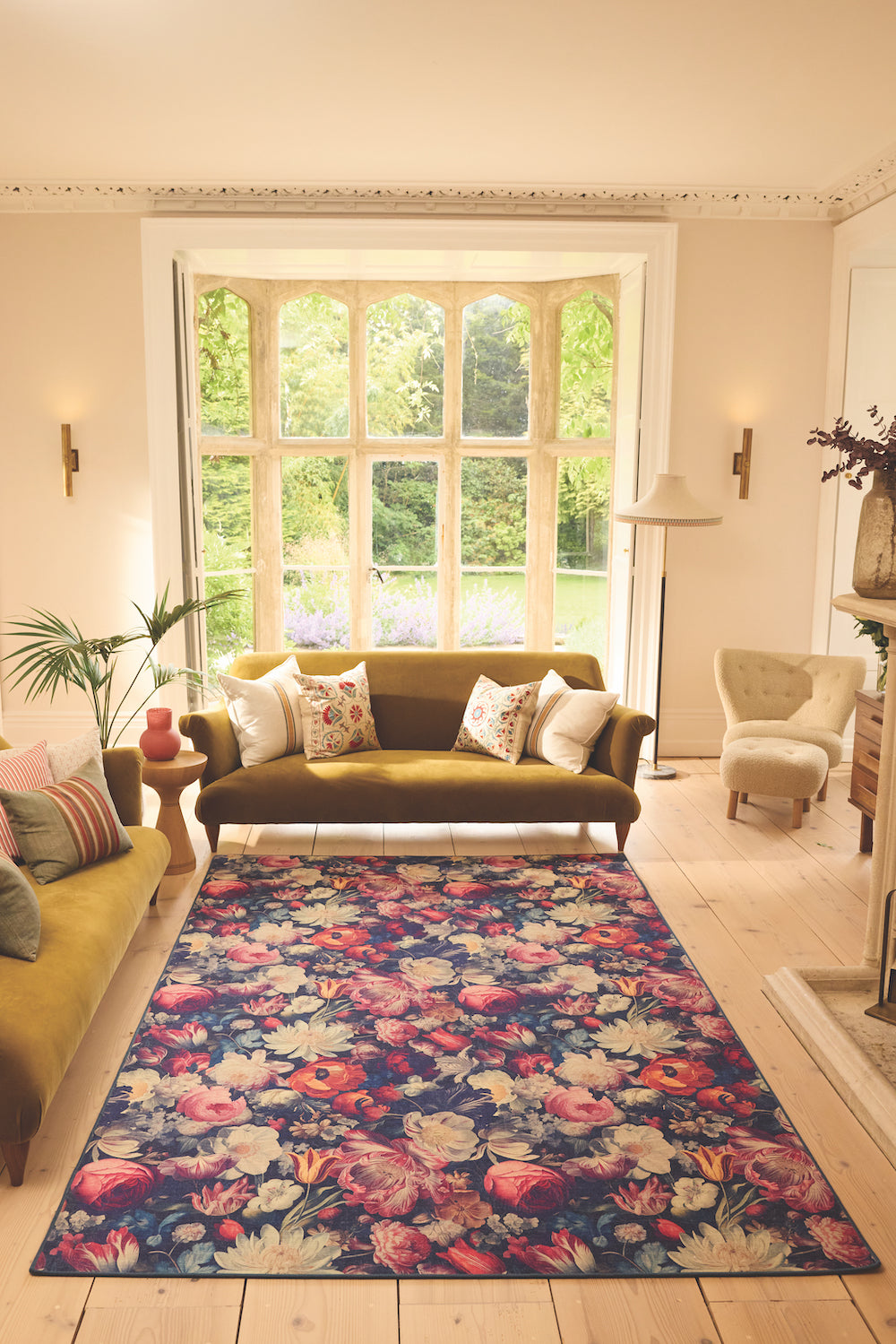 A Signature Collection flowered rug on a wooden floor in a sunny living room