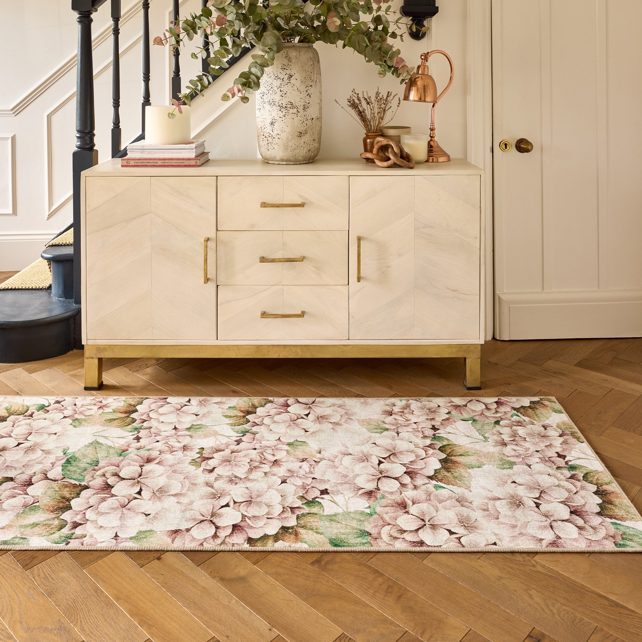 Floral hydrangea rug on a wooden floor in hallway with a cabinet in the background